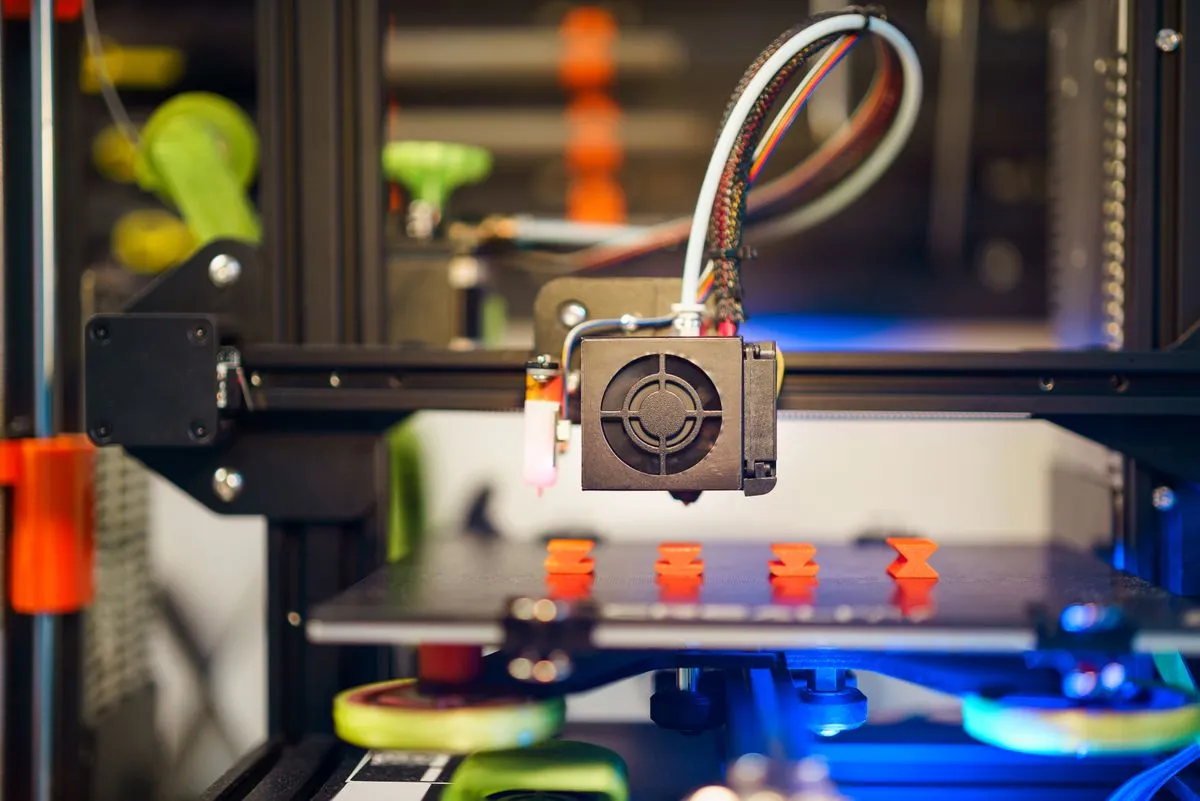 Impresora 3D fabricando piezas pequeñas de plástico