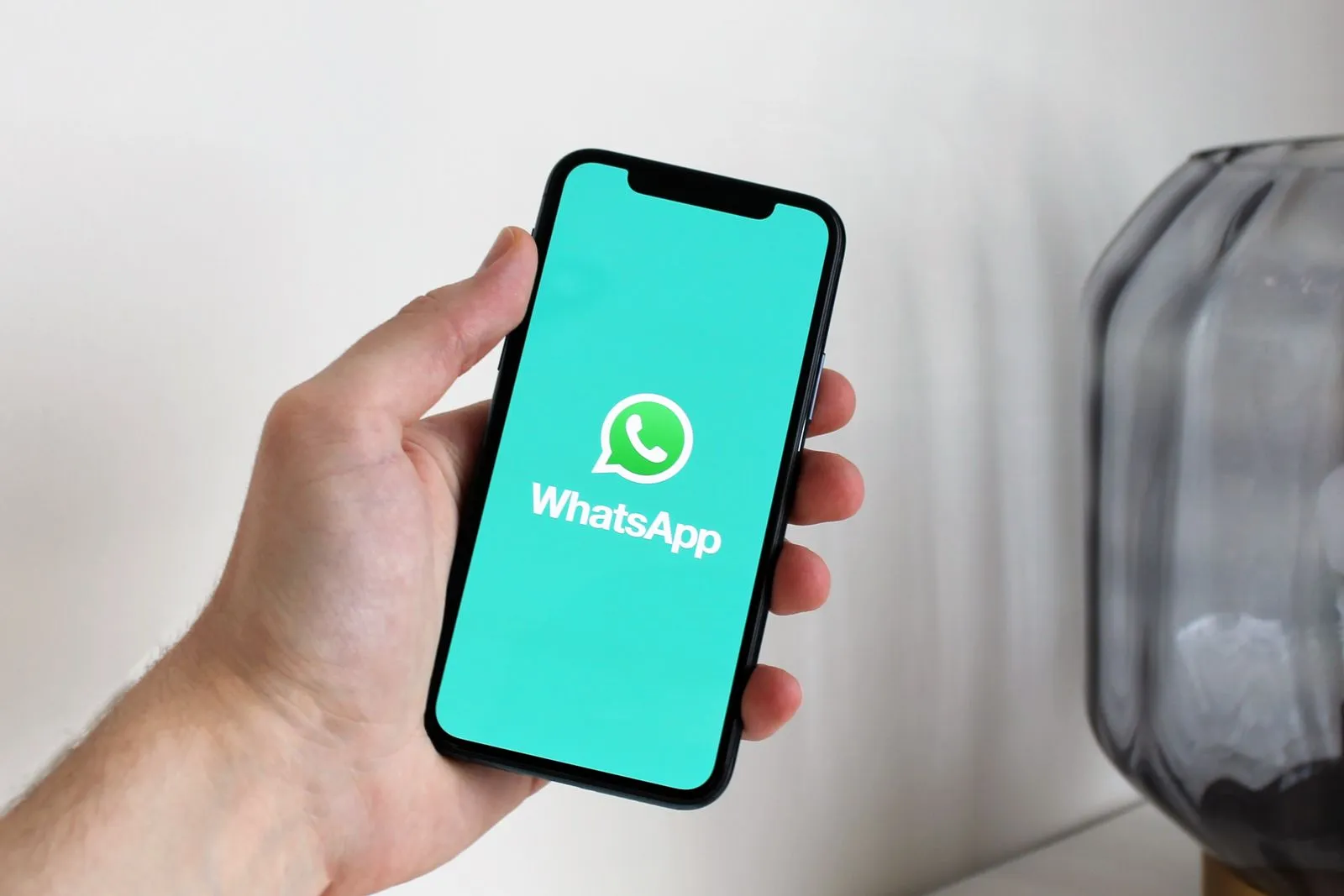 Mano sosteniendo un celular con WhatsApp abierto